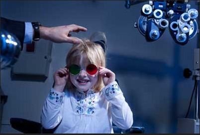 child getting an eye exam with two different lenses